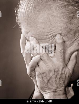 1970s SENIOR MAN HOLDING HIS HEAD IN HIS HANDS COVERING HIS FACE - p7733 HAR001 HARS STUDIO SHOT MOODY PRAYER ILLNESS COPY SPACE PERSONS MALES RISK AFRAID AILMENT SENIOR MAN COVERING SENIOR ADULT EXPRESSIONS TROUBLED B&W CONCERNED SADNESS ANXIETY SUFFERING OLD AGE OLDSTERS HEAD AND SHOULDERS OLDSTER ANXIOUS HIS AGING GENERATION MOOD SHAME ELDERS GLUM THREATENED EMBARRASSMENT FEARFUL UNEASY ELDERLY MAN POOR HEALTH AILING MISERABLE BLACK AND WHITE CAUCASIAN ETHNICITY HAR001 OLD FASHIONED Stock Photo