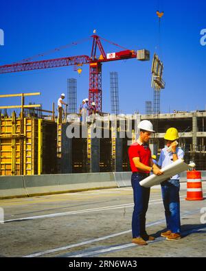 1990s CONSTRUCTION SITE TWO MEN REVIEWING PLANS WEARING HARD HATS JEANS ONE HOLDING MOBILE PHONE CRANE & WORKERS IN BACKGROUND - ks29403 GRD001 HARS TEAMWORK ENGINEER ARCHITECTURE SITE COMMUNICATING MANAGER PLANS COPY SPACE FULL-LENGTH PERSONS MALES ARCHITECT BUILDINGS EXECUTIVES CRANE GOALS PROPERTY EXTERIOR LABOR SUPERVISOR EMPLOYMENT OCCUPATIONS PHONES REAL ESTATE BOSSES REVIEWING STRUCTURES TELEPHONES EDIFICE EMPLOYEE CREATIVITY MANAGERS MID-ADULT MID-ADULT MAN SOLUTIONS CAUCASIAN ETHNICITY CONTRACTOR LABORING OLD FASHIONED Stock Photo