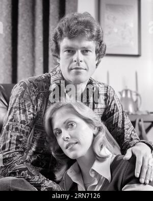 1970s PORTRAIT OF COUPLE SERIOUS FACIAL EXPRESSIONS MAN SITTING IN CHAIR WOMAN ON FLOOR WEARING TRENDY FASHION LOOKING AT CAMERA - p8534 HAR001 HARS HUSBANDS HOME LIFE COPY SPACE FRIENDSHIP LADIES PERSONS THOUGHTFUL CARING MALES TRENDY EXPRESSIONS B&W PARTNER EYE CONTACT DREAMS HEAD AND SHOULDERS CONNECTION STYLISH SINCERE PERSONAL ATTACHMENT SOLEMN AFFECTION EMOTION FOCUSED INTENSE MID-ADULT MID-ADULT MAN MID-ADULT WOMAN TOGETHERNESS WIVES BLACK AND WHITE CAREFUL CAUCASIAN ETHNICITY EARNEST HAR001 INTENT OLD FASHIONED Stock Photo