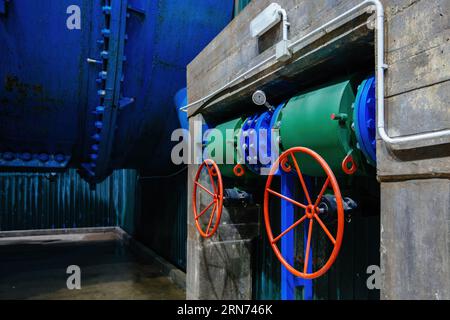 Plumbing pipe with two valves and pressure gauge. Water pressure regulation in hydroelectric power plant. Stock Photo