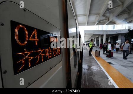 (150817) -- HARBIN, Aug. 17, 2015 -- Passengers wait to board the train at the Qiqihar South Railway Station, northeast China s Heilongjiang Province, Aug. 17, 2015. China s northernmost high-speed railway between two cities of Harbin and Qiqihar in Heilongjiang started operation on Monday. With a designated speed of 250 kilometers per hour and eight stops, the trip from Harbin to Qiqihar was reduced from three hours to 85 minutes. The trains have been modified to adapt to temperatures as low as minus 40 degrees Celsius and resist adverse weather, such as strong winds, heavy rain, snow and fog Stock Photo