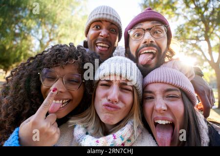 Winter selfie multiracial people together making funny faces in park. Group young mixed race friends Stock Photo