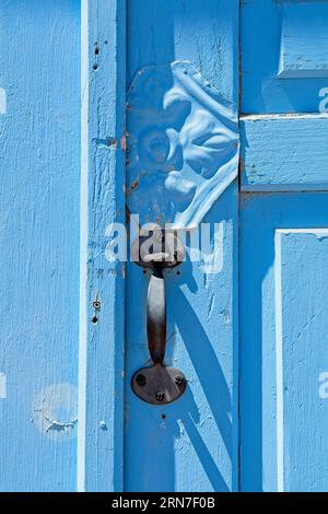 Close up iron gate latch on blue wood panel door Stock Photo
