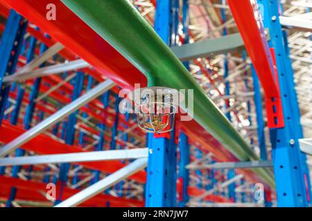 Fire sprinkler in a large warehouse with metal shelving Stock Photo