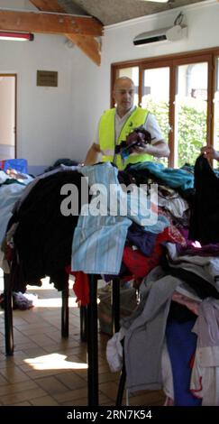 (150910) -- PARIS, Sept. 10, 2015 -- A staff member of Hubert Renaud center prepares clothes for refugees in Cergy-Pontoise near Paris, France, on Sept. 10, 2015. France opened its doors on Wednesday to 200 refugees from Syria and Iraq, the first slice of 24,000 asylum seekers that French President Francois Hollande pledged to take in the next two years. ) FRANCE-PARIS-REFUGEES ZhengxBin PUBLICATIONxNOTxINxCHN   Paris Sept 10 2015 a Staff member of Hubert Renaud Center Prepares Clothes for Refugees in  Pontoise Near Paris France ON Sept 10 2015 France opened its Doors ON Wednesday to 200 Refug Stock Photo