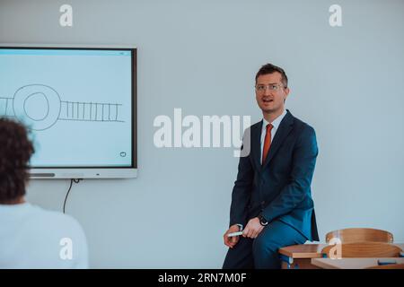 A modernly dressed professor engages in educating students, who listen attentively, creating a dynamic scene of knowledge-sharing and focused learning Stock Photo