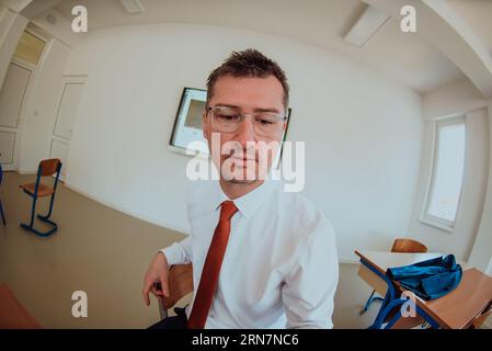 A modernly dressed professor engages in educating students, who listen attentively, creating a dynamic scene of knowledge-sharing and focused learning Stock Photo