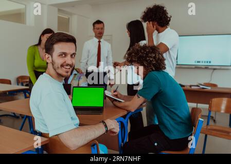 A group of business colleagues exchange knowledge and insights while utilizing laptops in the office, showcasing collaborative learning, effective Stock Photo