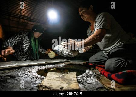(150923) -- TURPAN, Sept. 23, 2015 -- Photo taken on Sept. 16, 2015 shows Abduweli Rozi and his wife preparing to bake nang, a kind of crusty bread, at their workshop in Turpan, northwest China s Xinjiang Uygur Autonomous Region. Nearly every early morning, 45-year-old Abduweli Rozi and his wife wake up before 3 o clock and start their work. In the next 10 hours, they would make 300 nang and distribute to sellers in the town. This is just one part of the story that took place everyday in a cooperative group of nang makers in Turpan. Besides Abduweli Rozi s famliy, 17 families work together in Stock Photo
