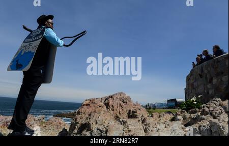 (151002) -- HERMANUS (SOUTH AFRICA), Oct. 2, 2015 -- The Hermanus Whale Cryer Eric Davalala (L) blows his Kelp Horn to announce where southern right whales have been sighted during the Hermanus Whale Festival in Hermanus, South Africa, on Oct. 2, 2015. The annual Hermanus Whale Festival kicked off here Friday, celebrating the returning of the southern right whales to this bay during the calving and mating season. More than 100,000 visitors are expected to come to Hermanus, which is known as the best land-based whale watching destination in the world. ) SOUTH AFRICA-HERMANUS-WHALE FESTIVAL Zhai Stock Photo