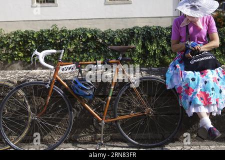 (151004) -- TUSCANY, Oct. 4, 2015 -- A bike fancier rests with her old bike outside the Eroica (heroic) vintage bike market in Gaiole in Chianti of Tuscany, Italy, on Oct. 3, 2015. A vintage bike market was held in Gaiole in Chianti from October 2 to October 4, as a part of the Eroica (heroic) cycling race for old bikes, which was founded in 1997, and takes place every October in Gaiole in Chianti. More than 5,500 participants from all over the world were attracted in this non professional event for classic bikes this year.) (zhf) ITALY-TUSCANY-VINTAGE BIKE MARKET JinxYu PUBLICATIONxNOTxINxCHN Stock Photo