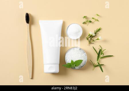 Flat lay composition with toothbrush, toothpaste and herbs on beige background Stock Photo