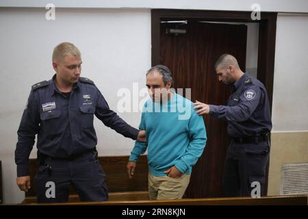 (151028) -- JERUSALEM, Oct. 28, 2015 -- Hagai Amir (C), the brother and primary accomplice to the assassin of Israel s former prime minister Yitzhak Rabin, is guarded by Israeli prison guard officers prior to a court session at a court in Tel Aviv, Israel, on Oct. 28, 2015. The brother and primary accomplice to the assassin of Israel s former prime minister Yitzhak Rabin was detained by the police on Tuesday over a Facebook post wishing the Israeli President would soon pass from the world. The post by Hagai Amir, brother of convicted assassin Yigal Amir, came at the time when Israel is commemo Stock Photo