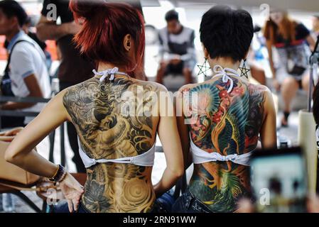 151114) -- BANGKOK, Nov. 14, 2015 -- A man demonstrates his tattoo during  the MBK Tattoo Contest in Bangkok, Thailand, Nov. 14, 2015. Hundreds of  tattoo fans gather in Bangkok on Saturday