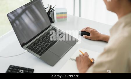 Developer programmer use mouse and checking code on laptop while programming to developing website. Stock Photo