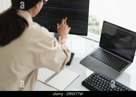 Developer programmer checking code on monitor while programming to developing web and application. Stock Photo