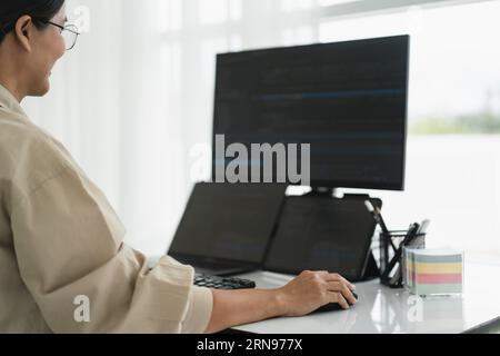 Developer programmer checking code on multiple monitor while programming to developing web and apps. Stock Photo