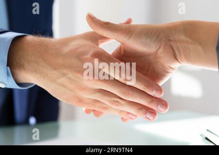 Elevated View Of Businessman Shaking Hands With His Partner Over Desk Stock Photo