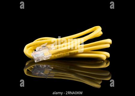 Internet data cable isolated on black background. Internet communication concept. Network internet yellow cable isolated over black with clipping path Stock Photo