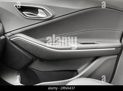 Door handle with Power window control buttons of a luxury passenger car. Black leather interior of the luxury modern car. Modern car interior details Stock Photo