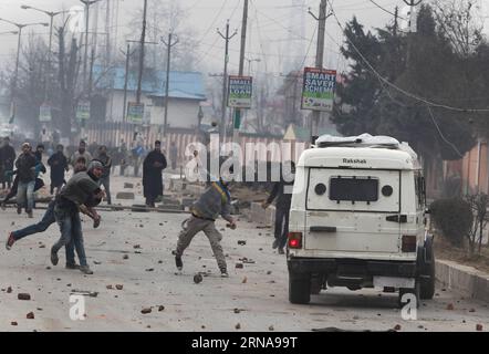 (160114) -- SRINAGAR, Jan. 14, 2016 -- Kashmiri protesters throw stones towards Indian police during a protest against the killing of Owais Bashir Malik, an engineering student, in Srinagar, summer capital of Indian-controlled Kashmir, Jan. 14, 2016. Indian police fired warning shots and tear gas shells to disperse hundreds of Kashmiri protesters who had blocked road to Srinagar airport and shouting anti-India slogans after the body of a college student with his throat slit was found in the Indian-controlled Kashmir. The protesters accused the Indian army of torturing and killing the student. Stock Photo