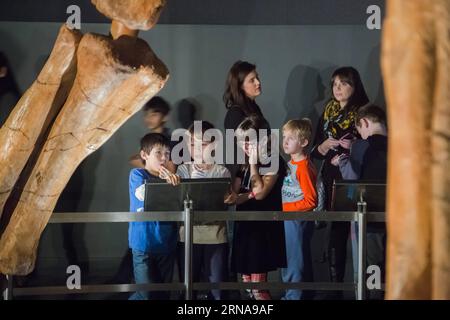 (160114) -- NEW YORK, Jan. 14, 2016 -- School children look at the Titanosaur skeleton exibition in the American Museum of Natural History in New York, the United States, Jan. 14, 2016. Starting from Jan. 15, the American Museum of Natural History will add another must-see exhibit -- a cast of a 122 foot (37.2m) dinosaur. The dinosaur has not yet been formally named by scientists who discovered it, but was inferred by paleontologists that it was a giant herbivore that belongs to a group known as titanosaurs weighing as much as 70 tons. The cast is based on 84 fossil bones that were excavated i Stock Photo