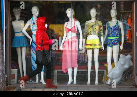 (160119) -- NINGBO, Jan. 19, 2016 -- A woman in thick winter dress walks on a street in Ningbo, east China s Zhejiang Province, Jan. 19, 2016. Most parts of China will experience a rapid drop in temperatures along with snow and rain in the coming days as a strong cold front is on the way, and will disrupt travel for the upcoming Spring Festival, which falls on Feb. 8 this year. The National Meteorological Center said temperatures will drop sharply in northwestern, northern and northeastern China, with temperatures in some areas down by up to 14 degrees Celsius. )(wjq) CHINA-COLD WAVE (CN) Zhan Stock Photo