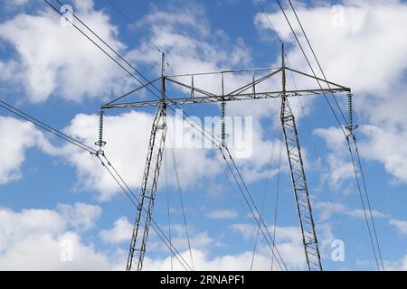 Overhead high voltage power line pylon in use with 400 kV AC. Stock Photo