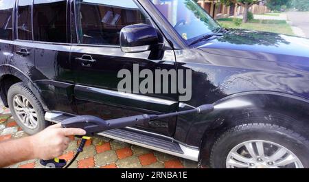 man washing car with car wash - pressure washer , shampoo, sponges and  microfiber car towels Stock Photo - Alamy