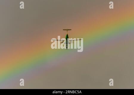 Plane with the rainbow in the background Stock Photo