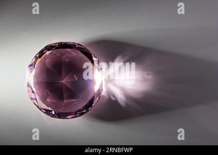 real glass object with shadows formed as diamond on white table with reflections Stock Photo