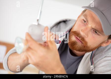 close image of man changing light bulb Stock Photo