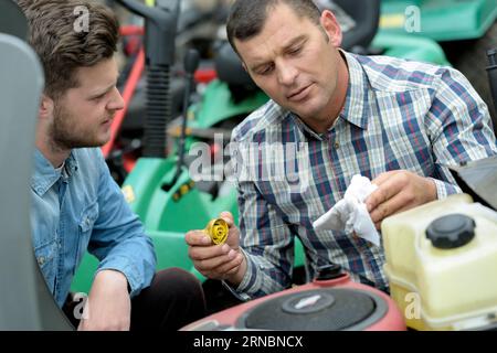 portrait of men repairing lawn mower engine Stock Photo
