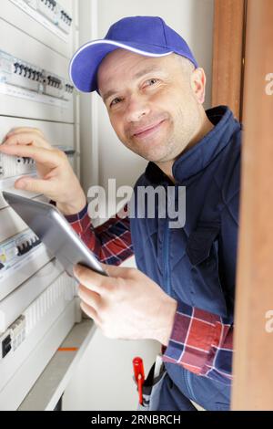 engineer switches on circuit breaker in electric switchboard close-up Stock Photo
