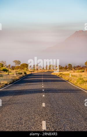 Low-hanging mist over the Larapinta Drive between Alice Springs (Mparntwe) and Simpsons Gap (Rungutjirpa) in the Northern Territory of Australia Stock Photo