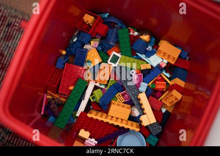 A collection of lego toys random picked up on red container. Stock Photo