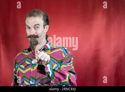 Hipster man confident showing approbation and pointing with finger at camera Stock Photo