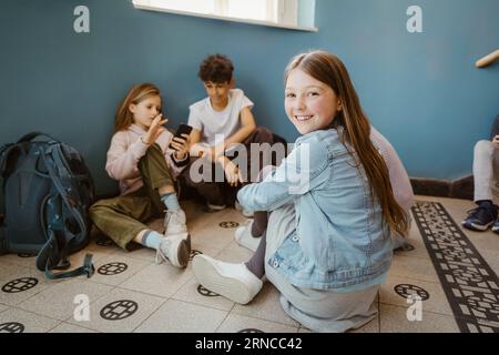 Smiling girl sitting on floor Stock Photo - Alamy