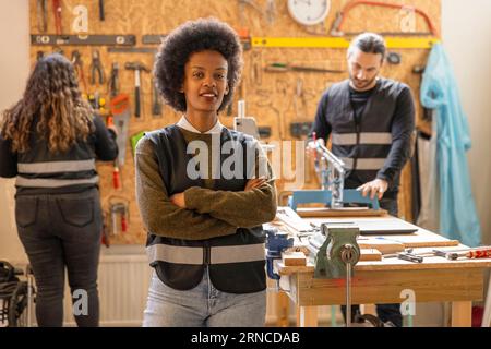 Portrait of confident female technician standing with arms crossed at recycling center Stock Photo