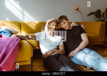 Portrait of smiling young man sitting with friend at home Stock Photo