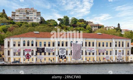Istanbul, Turkey - May 8 2023: View of the European side of Bosphorus with historic Neo-Classical building of Kabatas Erkek Lisesi or Kabatas High School, with green mountains in the background Stock Photo