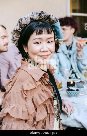 Portrait of smiling transwoman sitting during dinner party in back yard Stock Photo