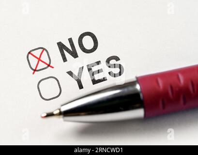 Check boxes yes or no on white paper. checkbox NO. marked with cross and red pen on white paper background. Vote No. answer choice no. vote against, r Stock Photo
