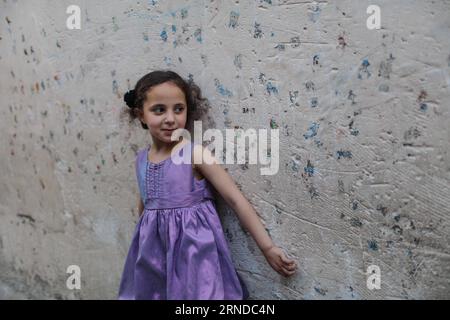 A Palestinian refugee girl plays outside her family's home during cold  weather in a slum in the northern Gaza Strip. With high rates of  unemployment in Gaza, an increasing number of families