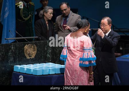 (160519) -- UNITED NATIONS, May 19, 2016 -- UN Secretary-General Ban Ki-moon(R) presents the Captain Mbaye Diagne Medal for Exceptional Courage to Ms. Yacin Mar Diop, the widow of Captain Diagne, on the occasion of the International Day of United Nations Peacekeepers, at the United Nations headquarters in New York, United States, May 19, 2016. The late Captain Diagne, a Senegalese military officer, saved hundreds of lives while serving as a peacekeeper during the 1994 Rwandan Genocide. The United Nations on Thursday honored fallen UN peacekeepers who lost their lives while serving under the UN Stock Photo