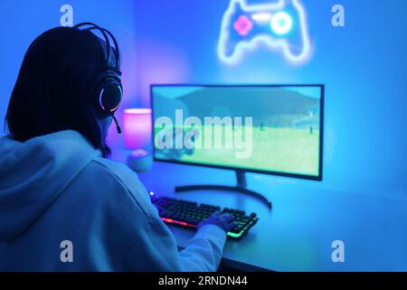 Young gamer playing online pc video games while streaming during Esport competition - Woman player enjoying gaming competition contest Stock Photo