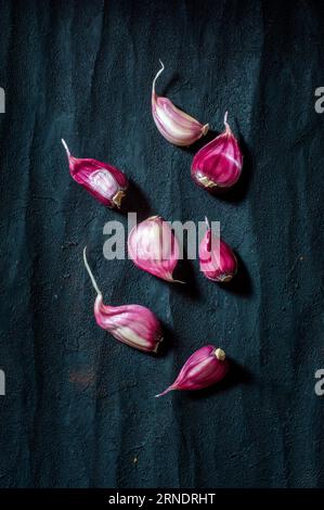 Purple garlic cloves on a black background Stock Photo