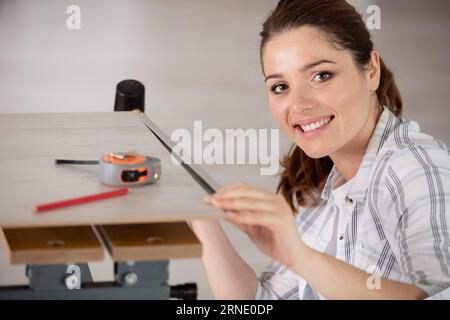 carpenter woman working using measuring tape Stock Photo