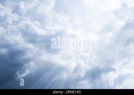Sky background. The rays of the sun break through dense dramatic clouds. Stock Photo