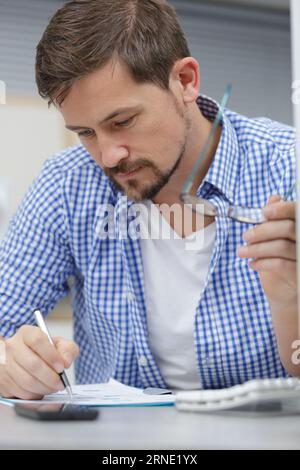 serious young man making notes while working with documents Stock Photo